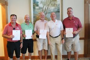 Dean of Engineering with a winning team holding award papers