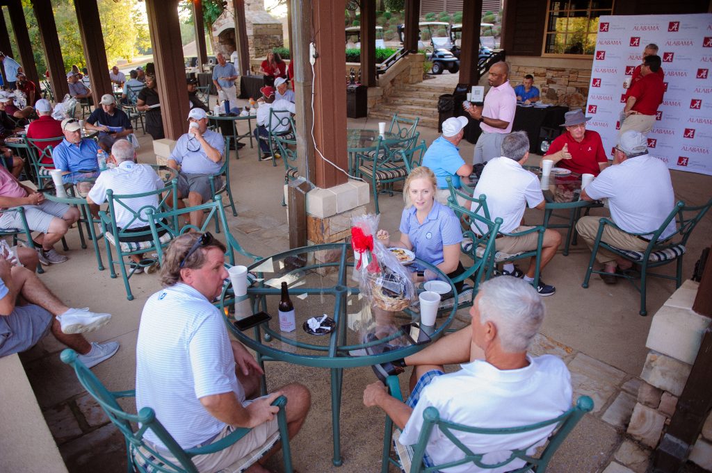large outdoor area with golfers eating and talking