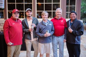 5 men, 4 holding golf ball gifts